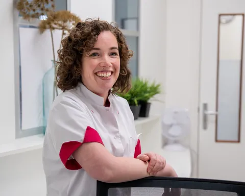 Een collega staat achter de balie en lacht je vriendelijk toe