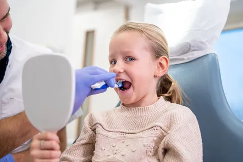 Kind poetst samen met ouder, preventieassistent kijkt mee