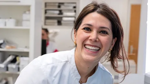 Medewerker van de praktijk lacht breed