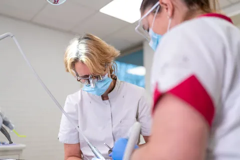 Assistent en tandarts werken samen aan de stoel