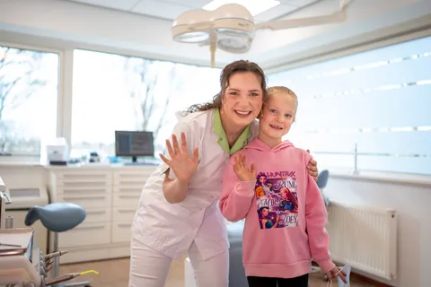 Kind en mondhygiënist zwaaien