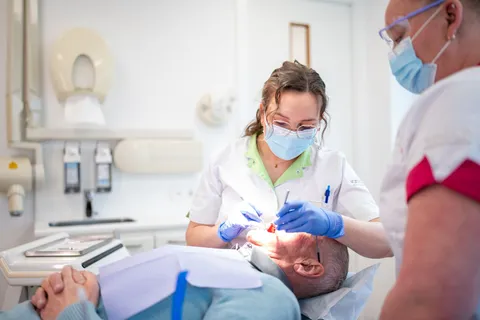 Mondhygiënist reinigt het gebit van een patiënt