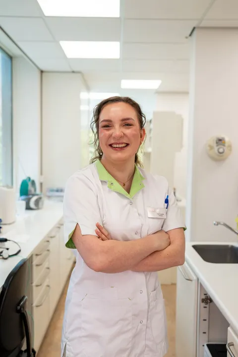 Medewerker met een natuurlijke glimlach in de behandelkamer