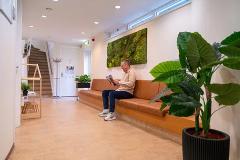 Patiënt kijkt zijn afspraak na in de wachtkamer